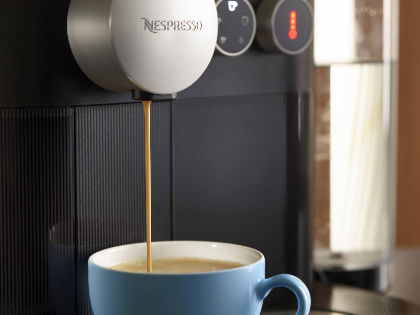 A Nespresso machine is preparing a single-serve coffee from a home-compostable cofffee capsule of Blue Circle Packaging.