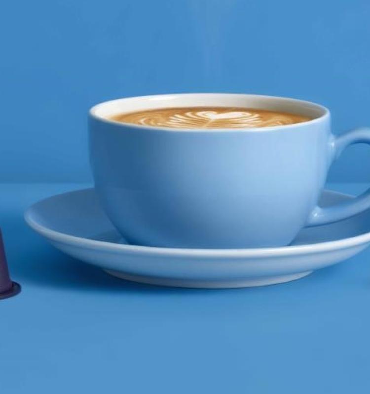 Biodegradable coffee capsules which are filled with quality coffee compatible in Nespresso machines on a blue background. Manufactured by Blue Circle Packaging