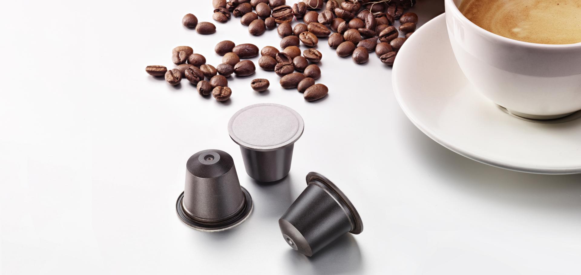 Biodegradable coffee capsules which are filled with quality coffee compatible in Nespresso machines on a white background